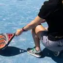 a woman sitting on a tennis court holding a racquet