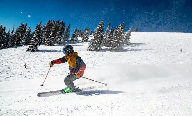 person in red jacket and blue pants riding on ski blades on snow covered ground during