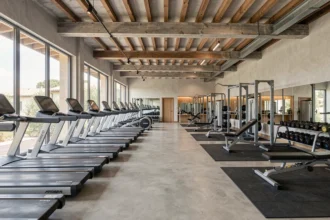 Vue panoramique d'une salle de sport moderne dans l'Hérault avec équipements fitness et zone de cardio
