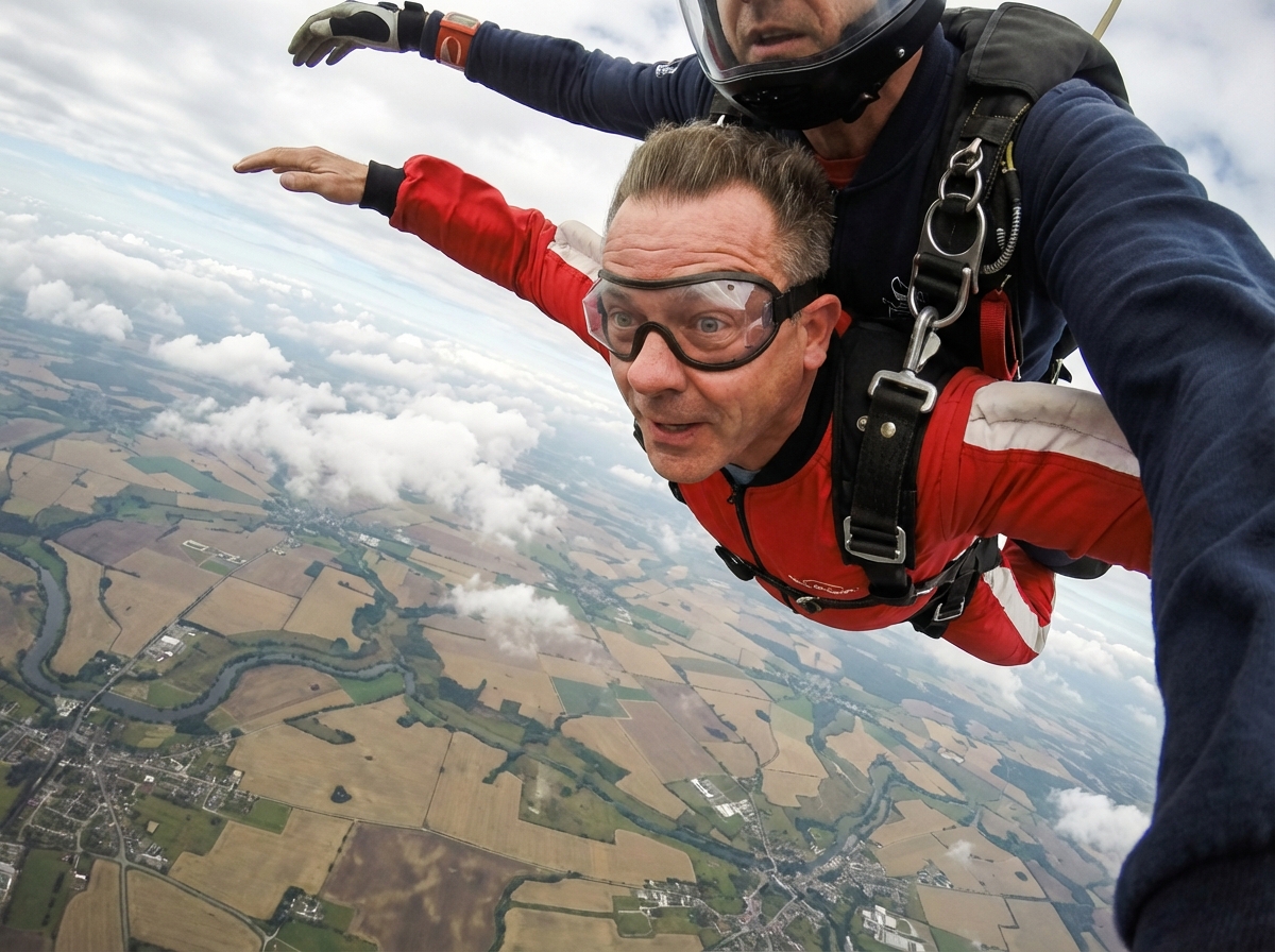 Homme en combinaison rouge lors d’un saut en tandem dans le ciel